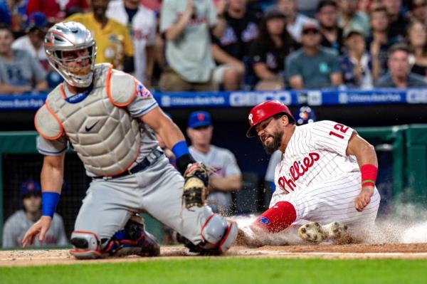 Kyle Schwarber slides safely into home to score on JT Realmuto's RBI single in the first inning of the Mets' 4-1 Game 2 loss to the Phillies.