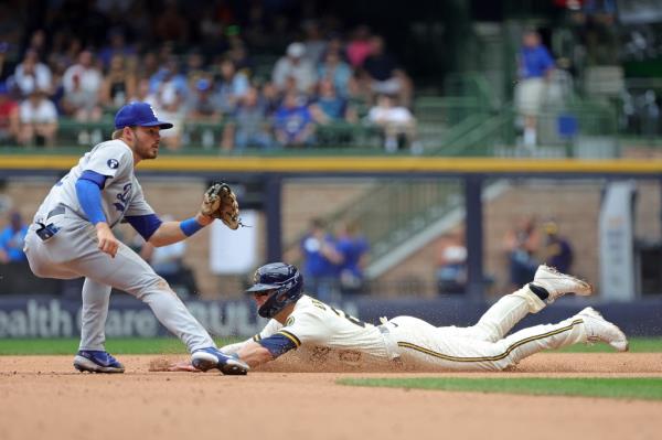 Mike Brosseau #20 of the Milwaukee Brewers beats a tag by Gavin Lux #9 of the Los Angeles Dodgers